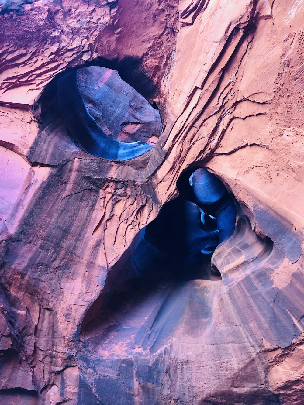 a cave in the side of a mountain with a blue face