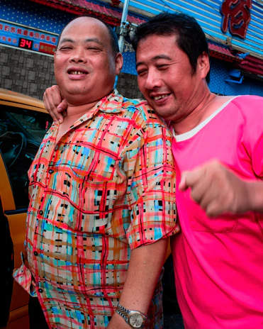 An Asian man and a Caucasian man enjoying a relaxed moment together outdoors, symbolizing authentic connection.