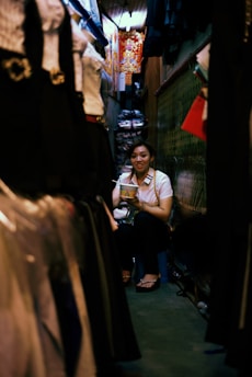 A cozy corner with a woman smiling while choosing clothes, reflecting comfort and emotional well-being.