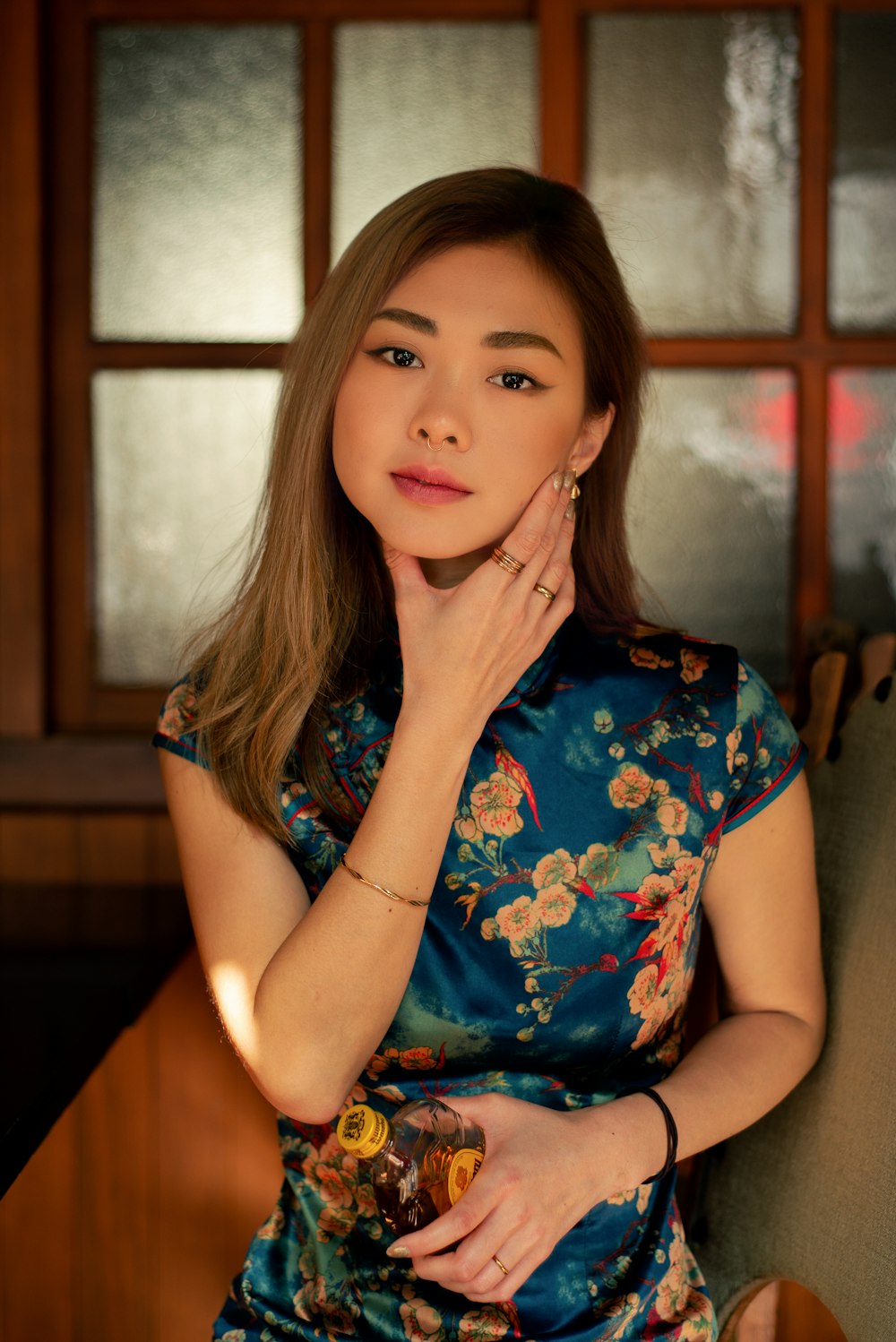 a woman sitting in a chair with her hand on her chin