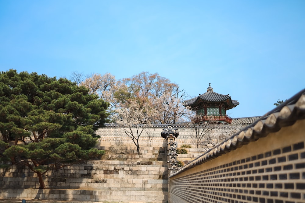 a stone wall with a building in the background