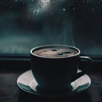 A steaming cup of specialty coffee on a wooden table by a window with soft morning light.