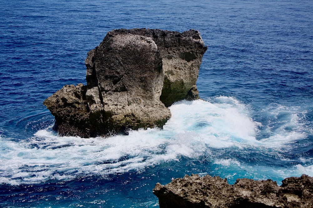 a large rock sticking out of the ocean