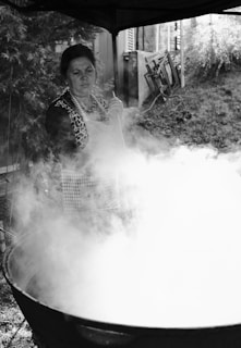 A gaucho woman stirring a pot of feijão tropeiro over an open fire.