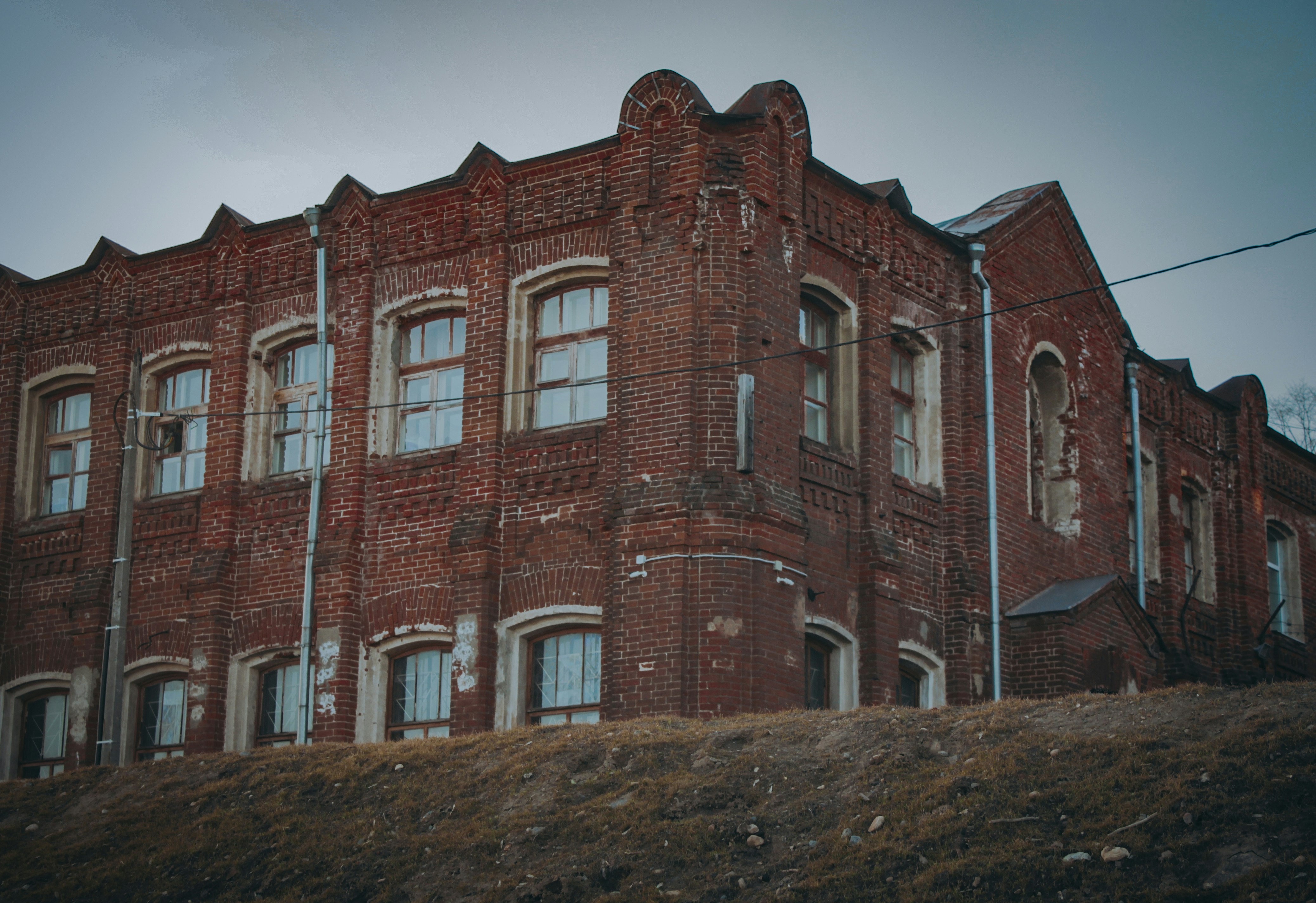 an old red brick building on a hill