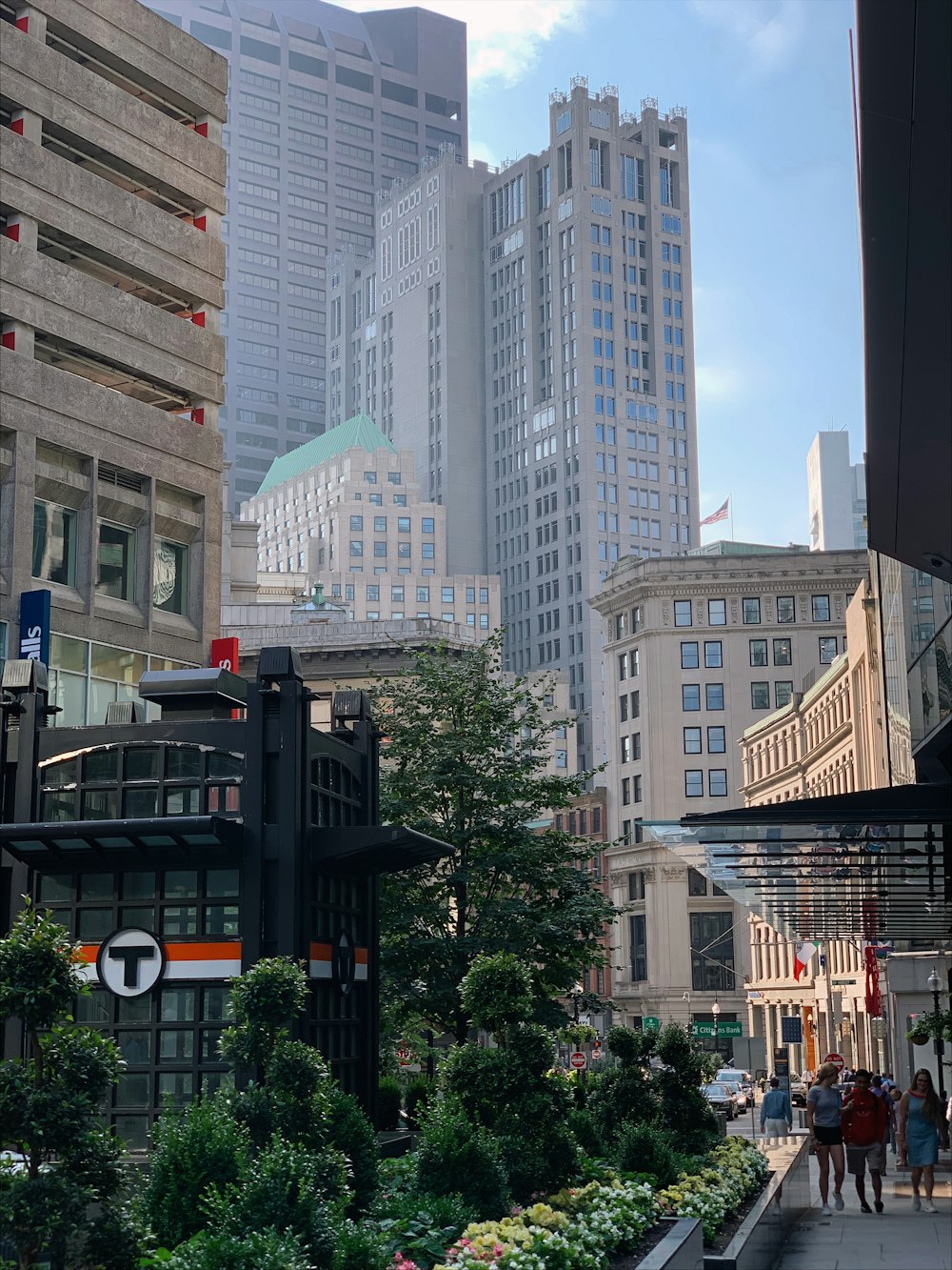 a group of people walking down a street next to tall buildings