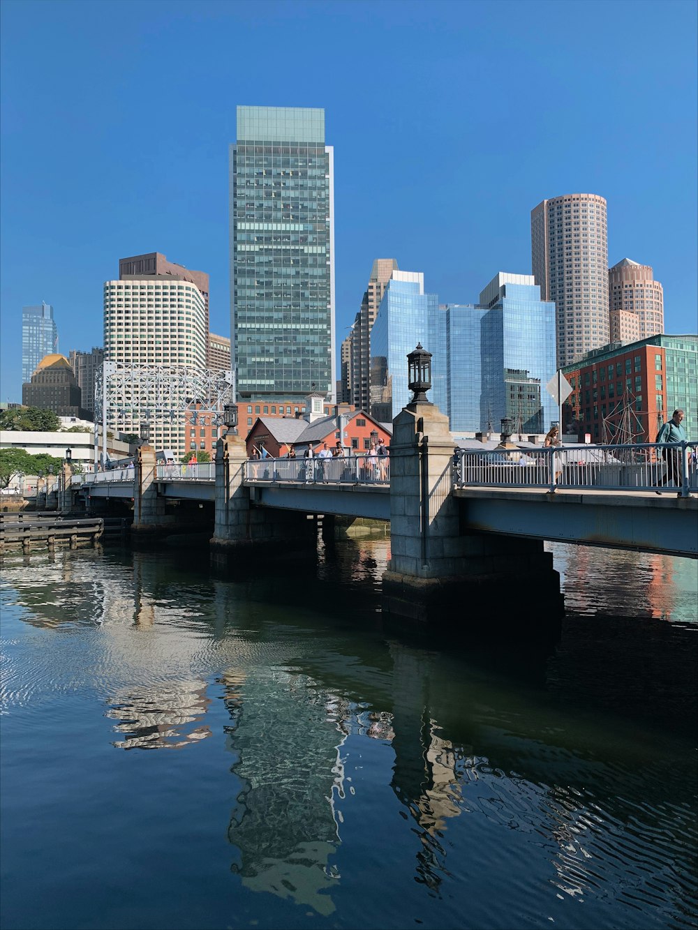 a bridge over a body of water with a city in the background