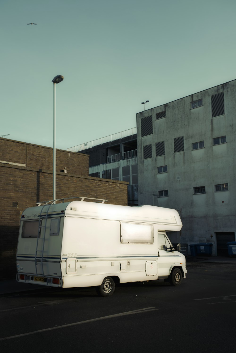 an rv parked in a parking lot next to a building