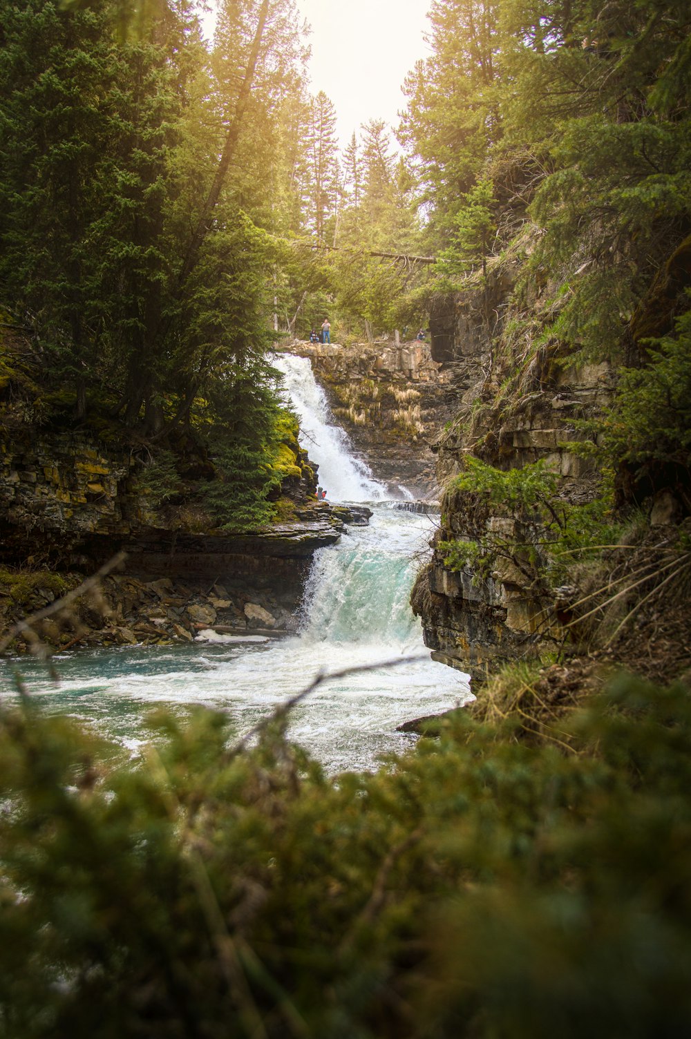 a man riding a surfboard on top of a waterfall