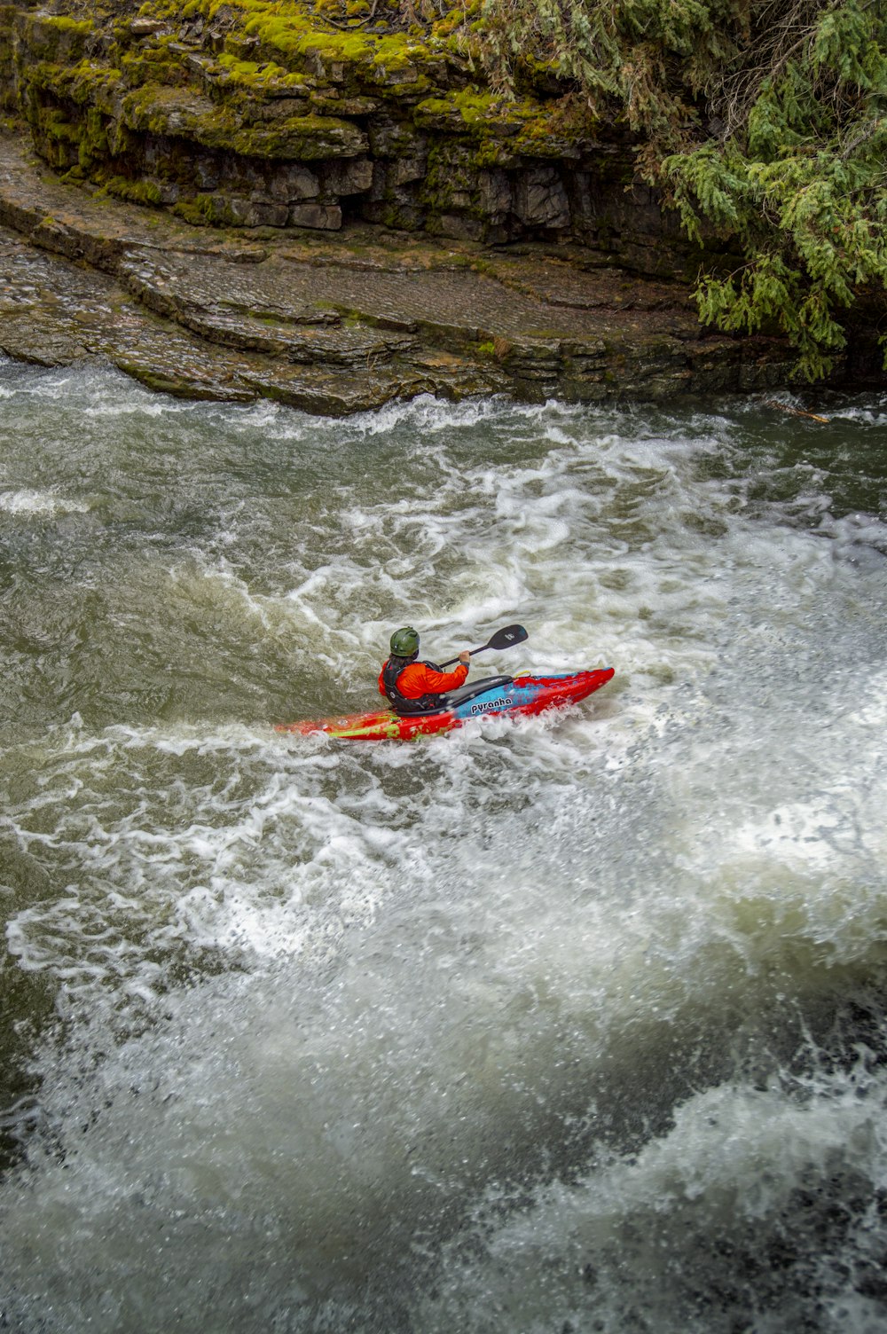 a man riding a kayak on top of a river