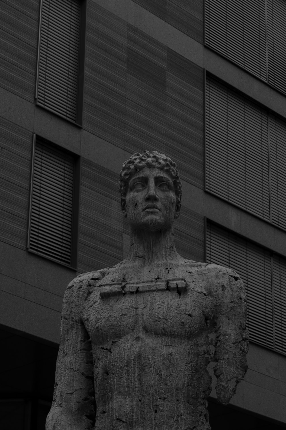 a black and white photo of a statue in front of a building