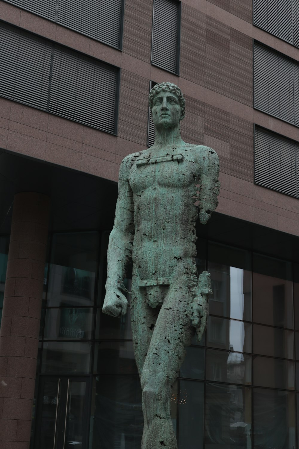 Una estatua de un hombre parado frente a un edificio