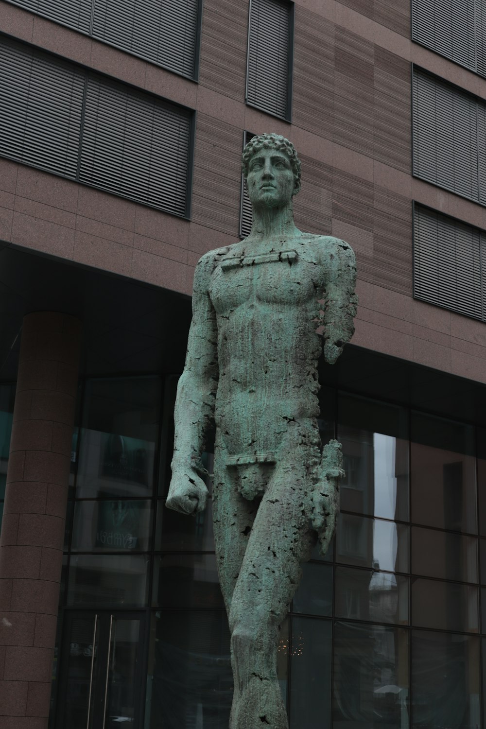 a statue of a man standing in front of a building