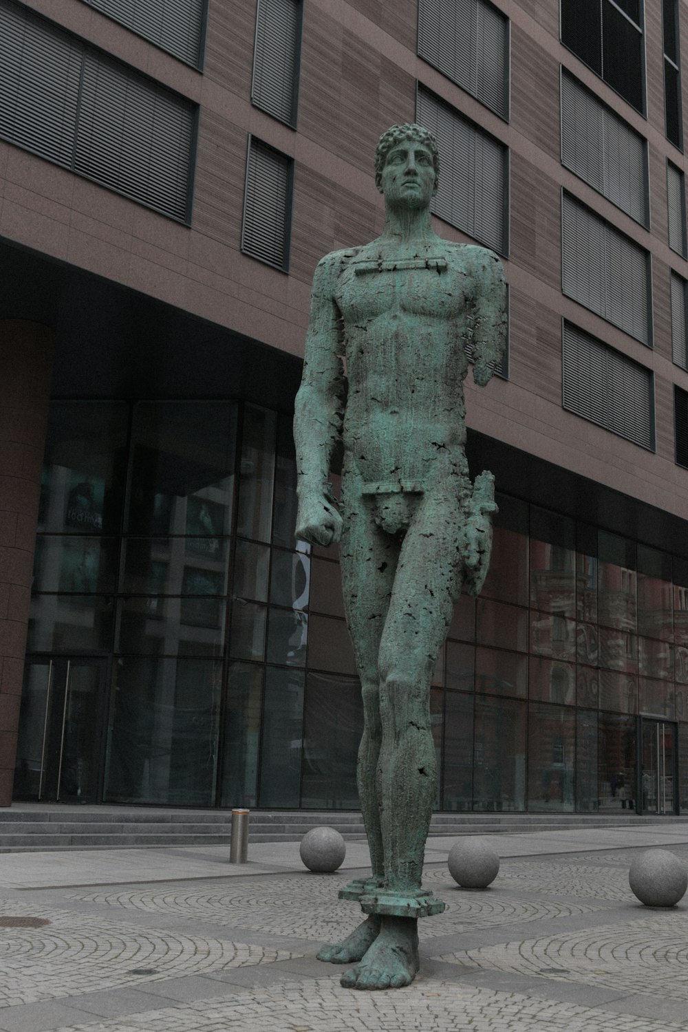 建物の前に立つ男の像