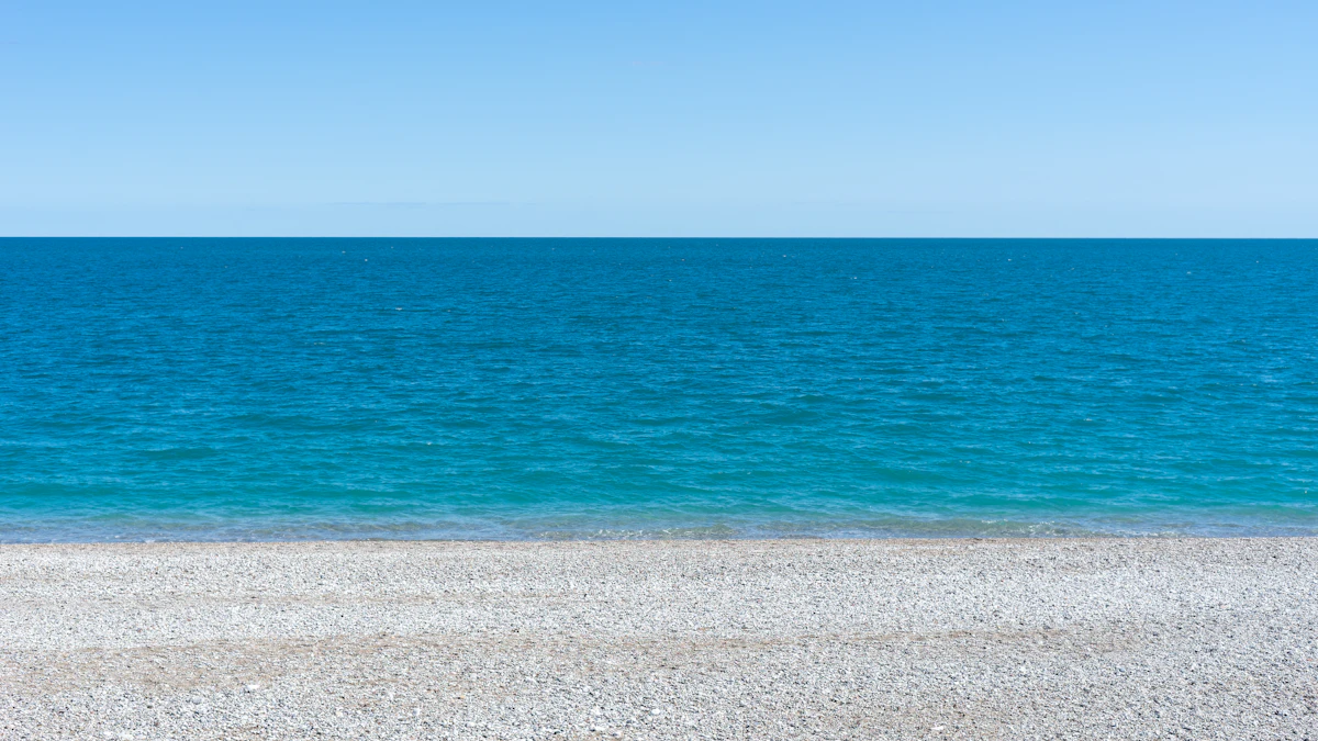 a bench sitting on top of a sandy beach next to the ocean