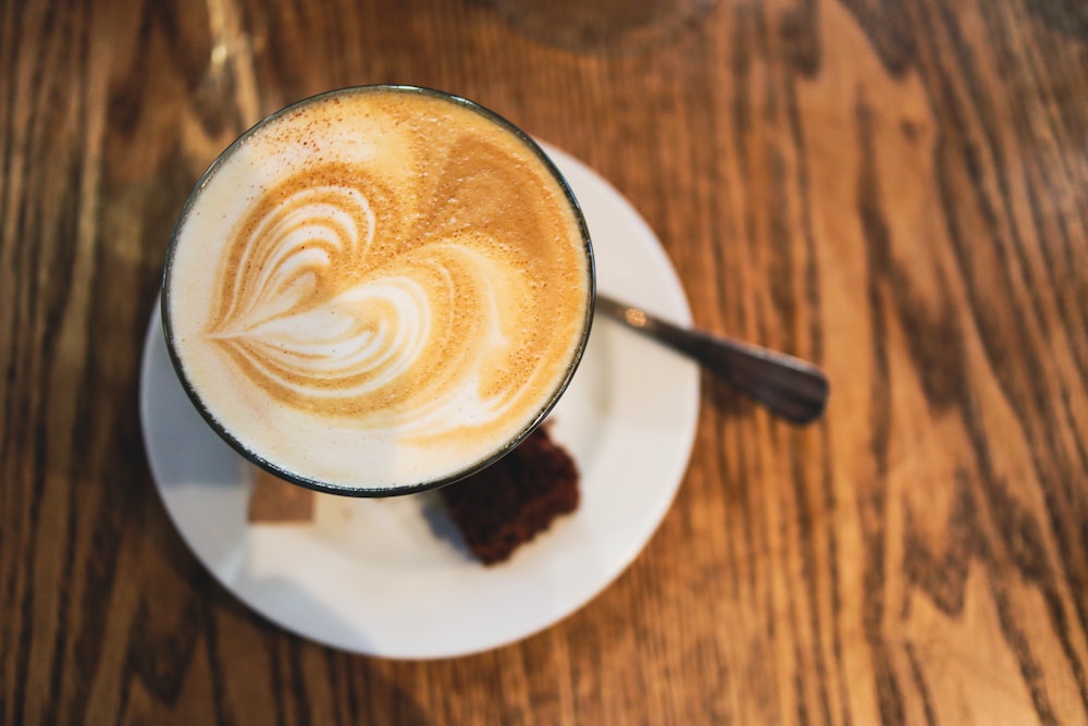 a cup of coffee on a saucer on a wooden table