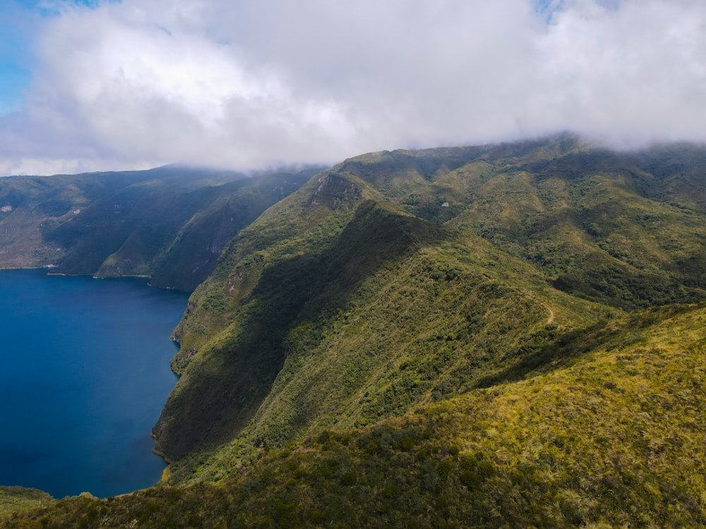 a large body of water surrounded by lush green hills