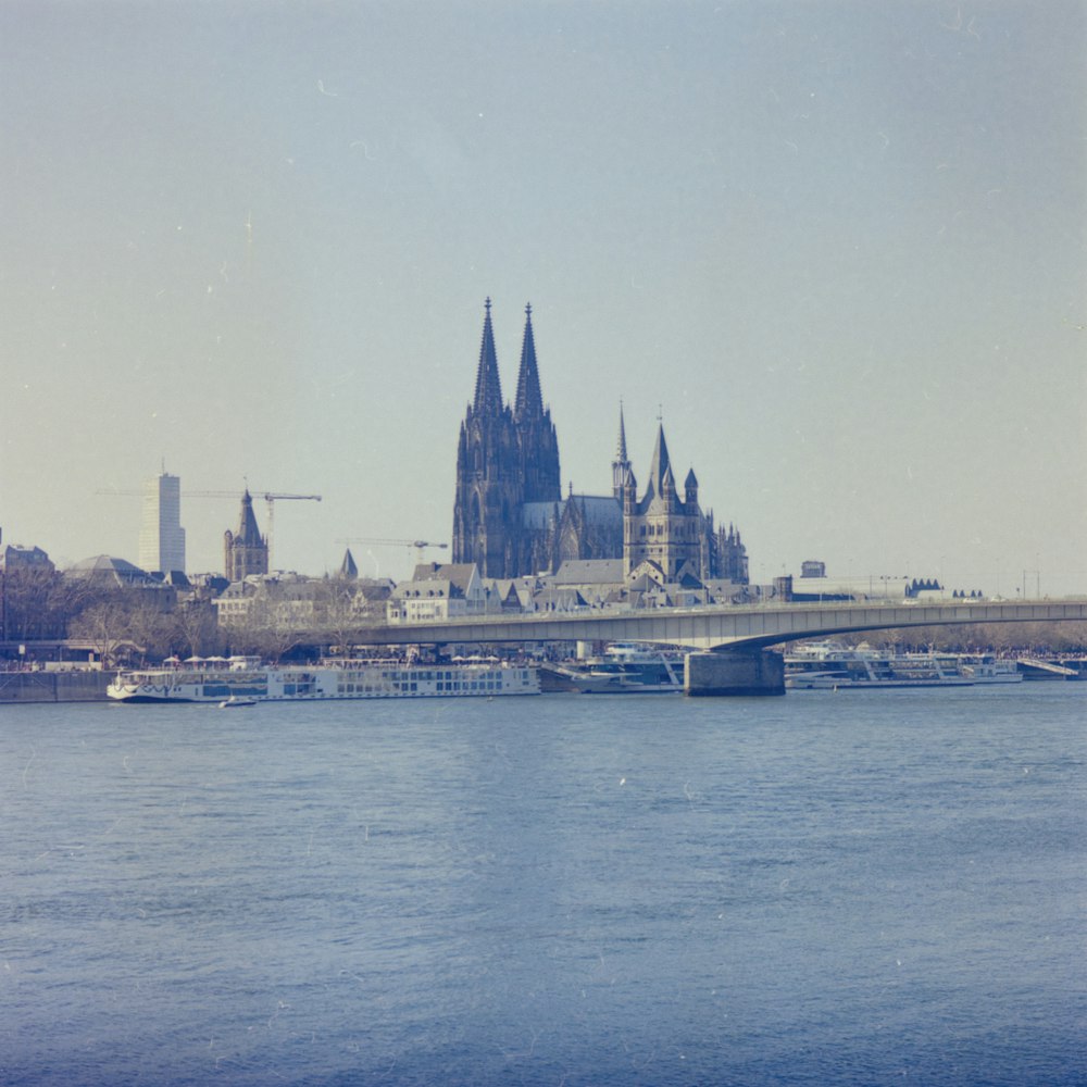 a bridge over a body of water with a castle in the background