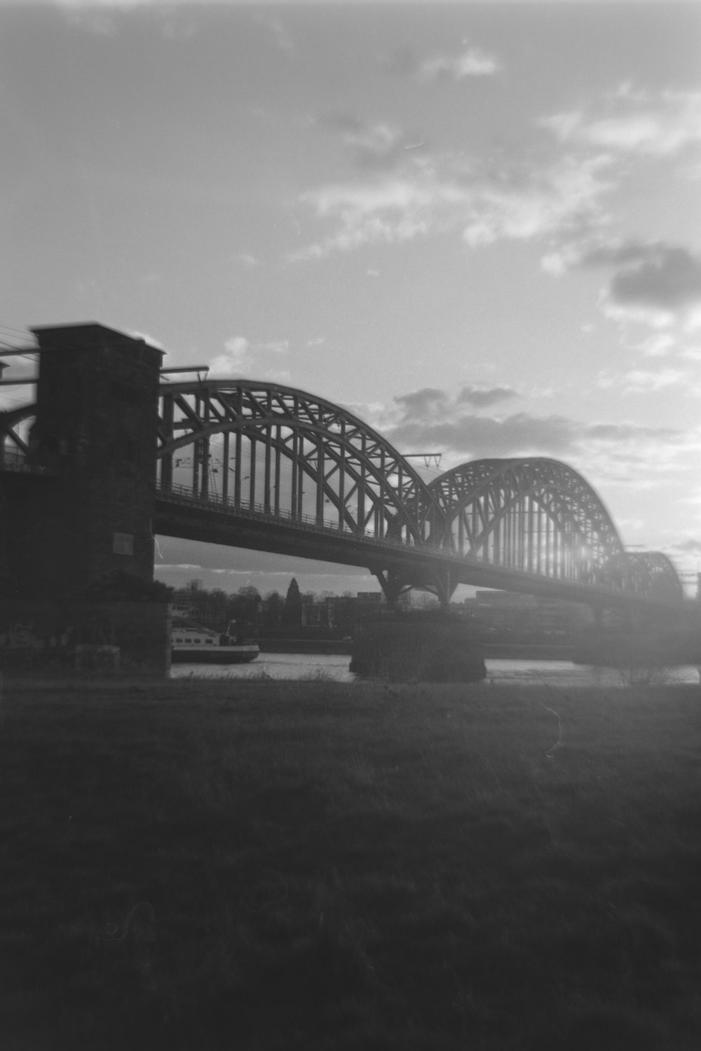 a large bridge spanning over a river under a cloudy sky