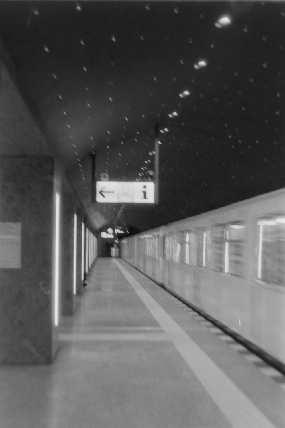 a black and white photo of a train pulling into a station