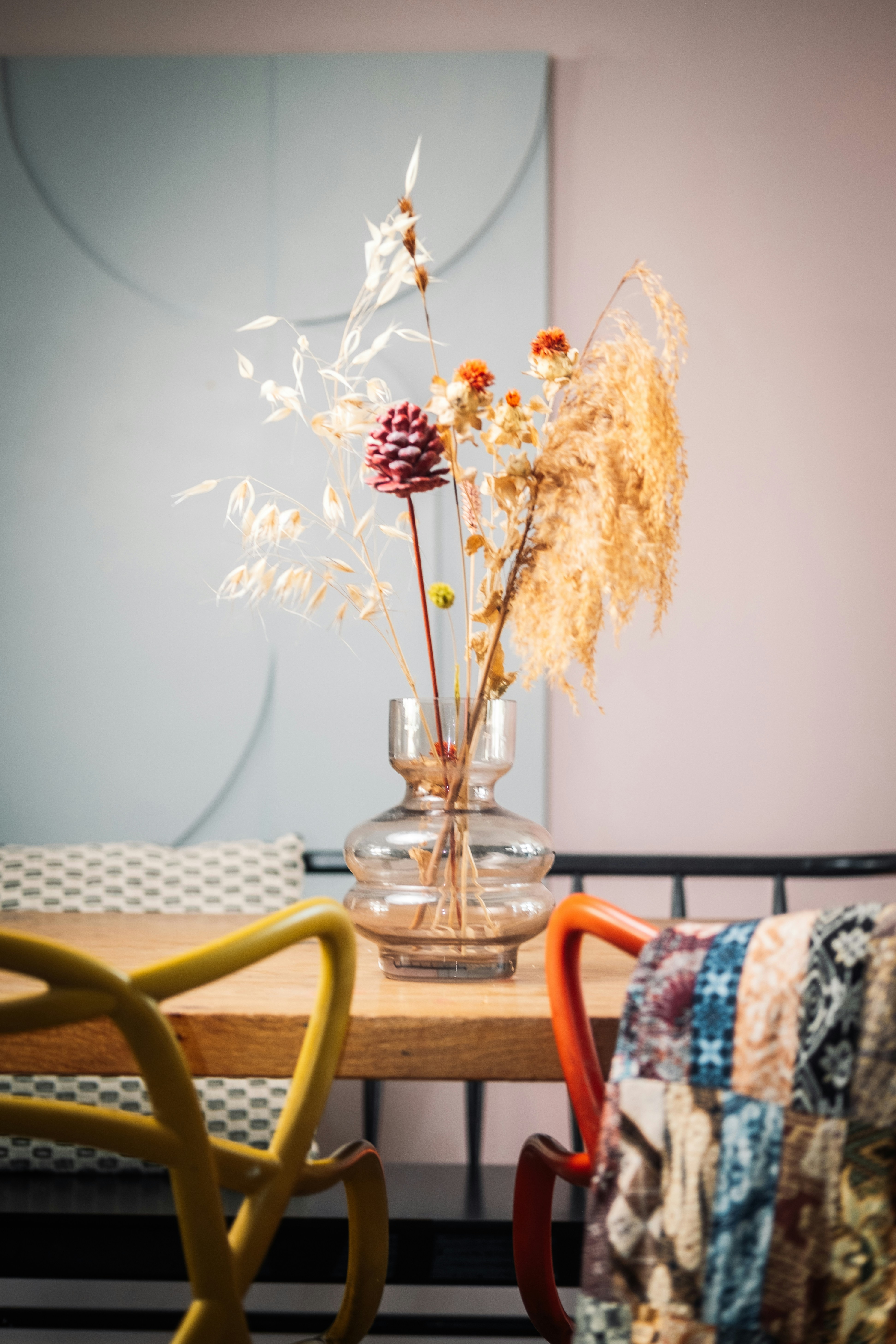 a vase with dried flowers in it sitting on a table