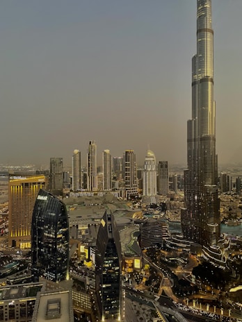 Evening cityscape featuring a softly lit contemporary structure standing out against the dusk.