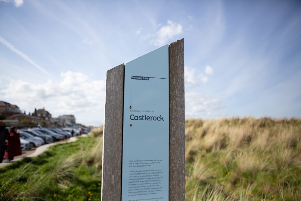 a sign on the side of a road near a field