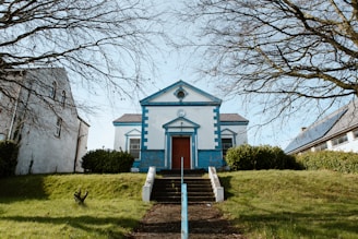 a blue and white church with a red door