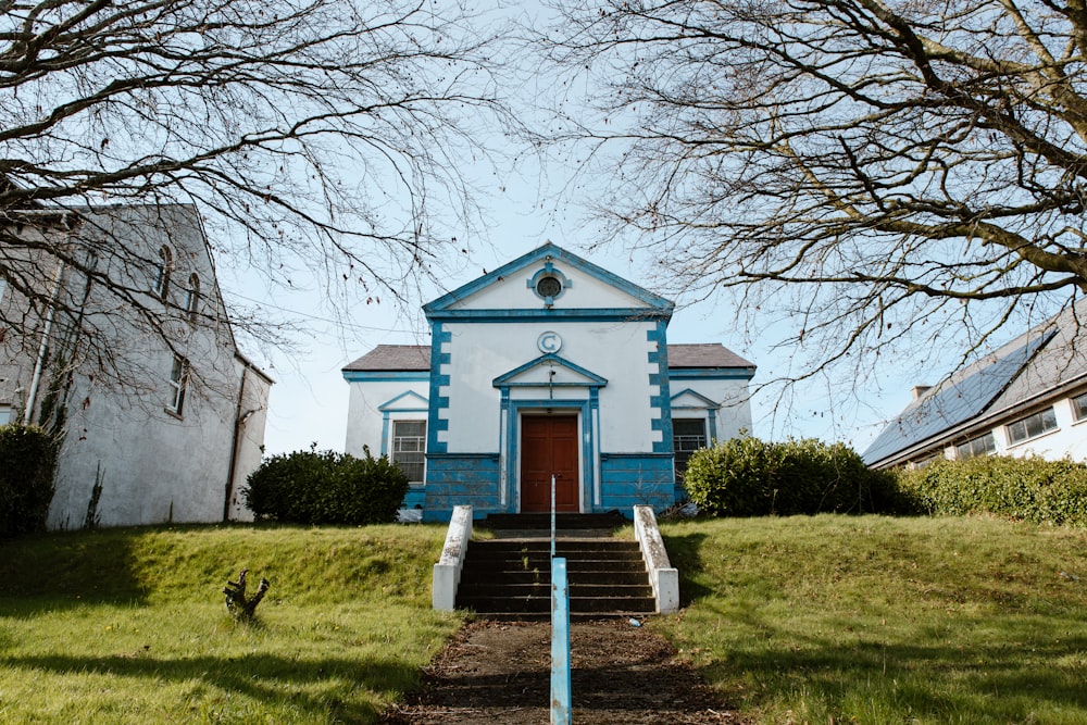 a blue and white church with a red door