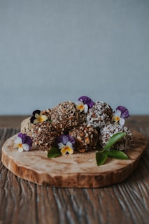 A rustic wooden table displaying rows of chocolate truffles dusted with cocoa powder and sprinkled with crushed peppermint.