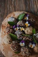 Artisanal chocolate truffles arranged on a rustic wooden board with cocoa powder dusting.