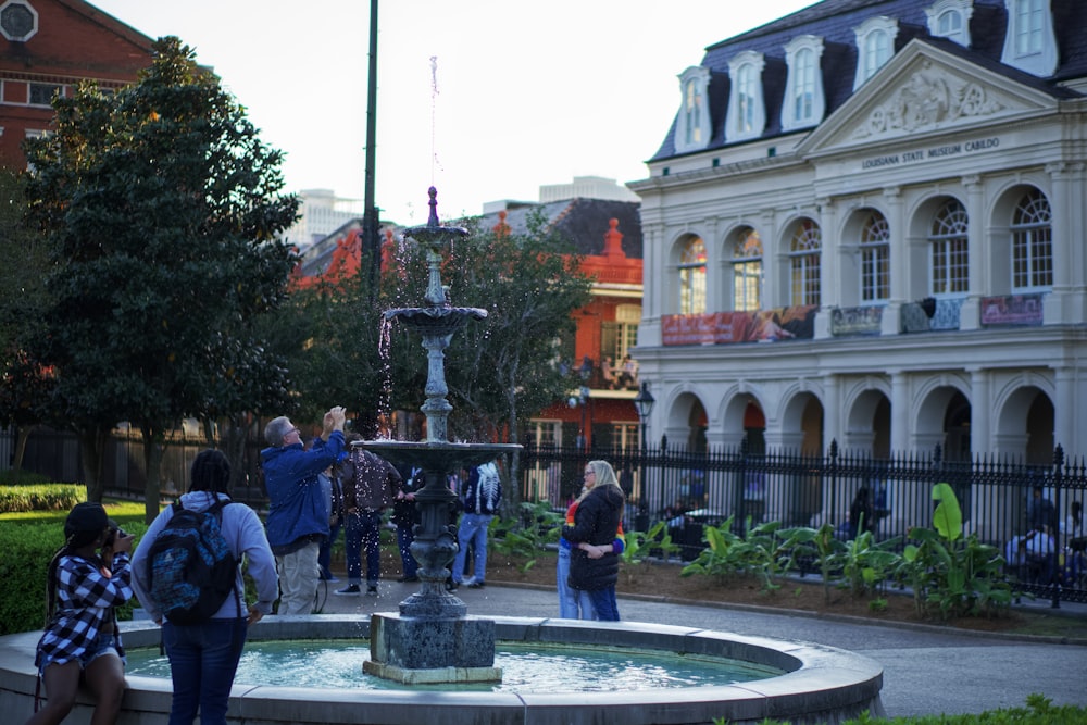 a group of people standing around a fountain