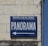 A blue sign on a brick wall with the words 'TOURING-CLUB DE FRANCE' in small letters and 'PANORAMA' in large letters, accompanied by an arrow pointing left.