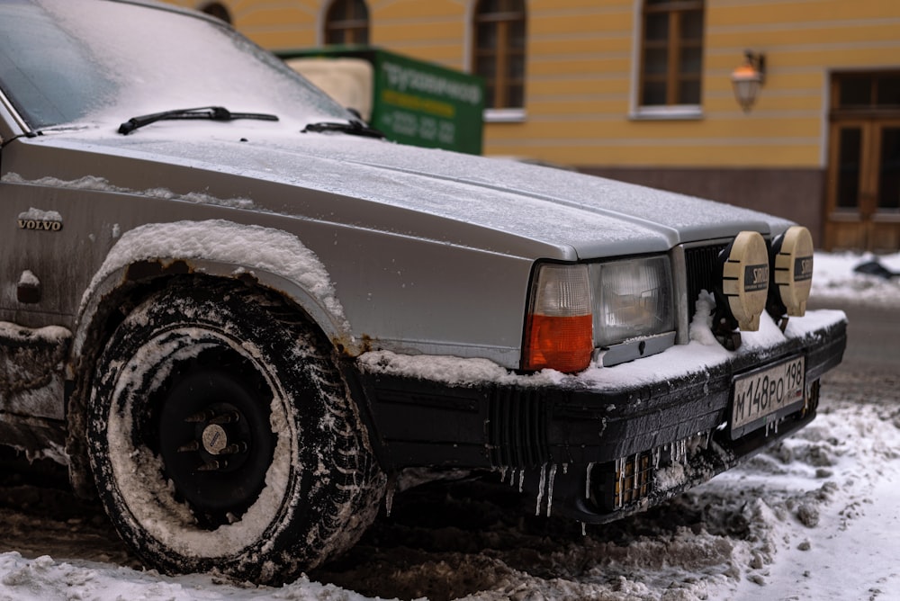 a car parked on the side of the road covered in snow