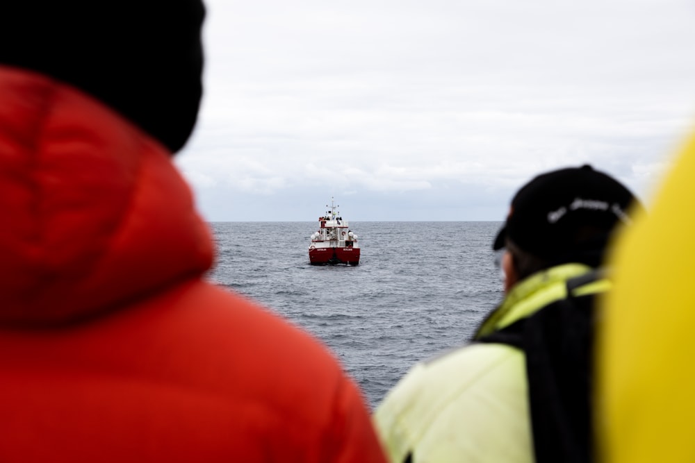 a red and white boat in the middle of the ocean