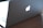 A laptop with a glowing logo on the back of the screen, placed on a wooden surface. The focus is on the illuminated logo, and the keyboard is partially visible.