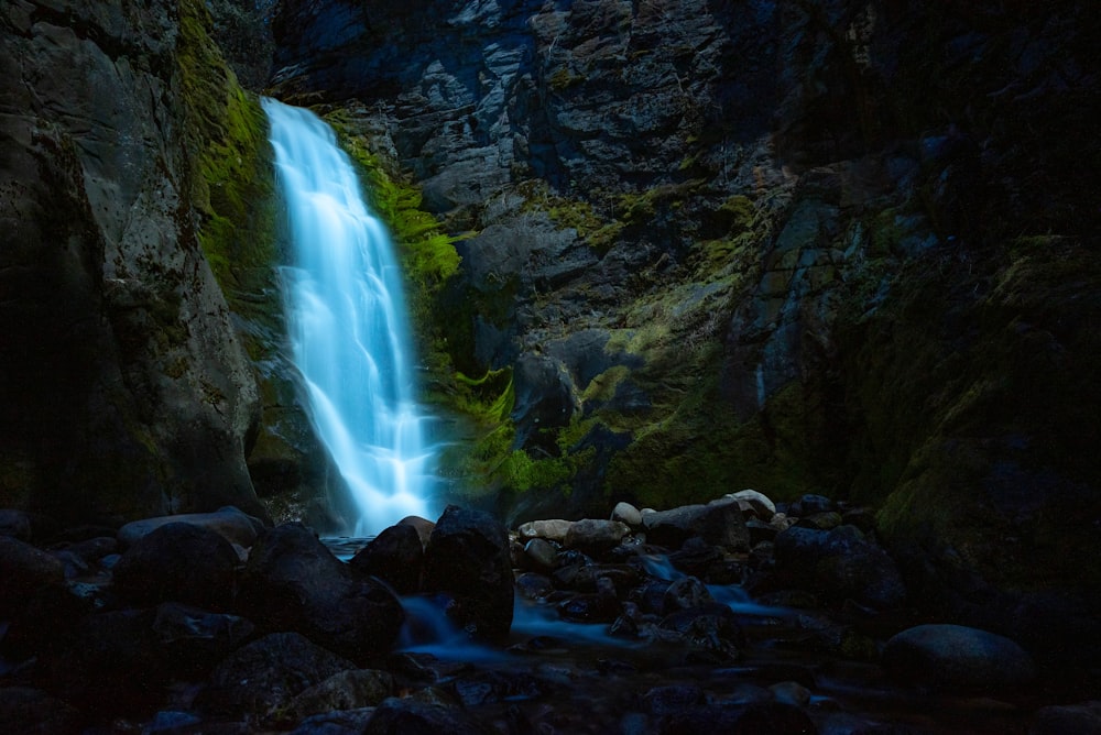 a small waterfall in the middle of a rocky area