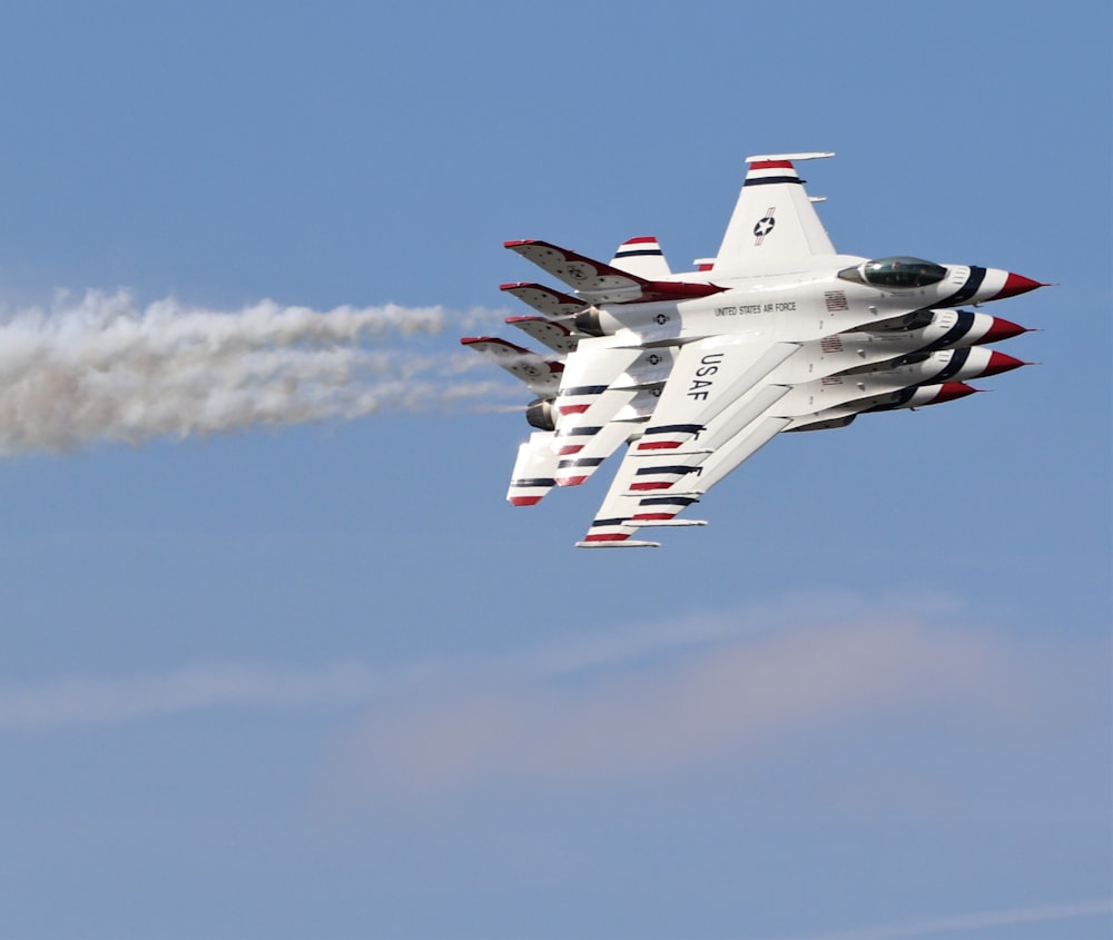 a fighter jet flying through a blue sky