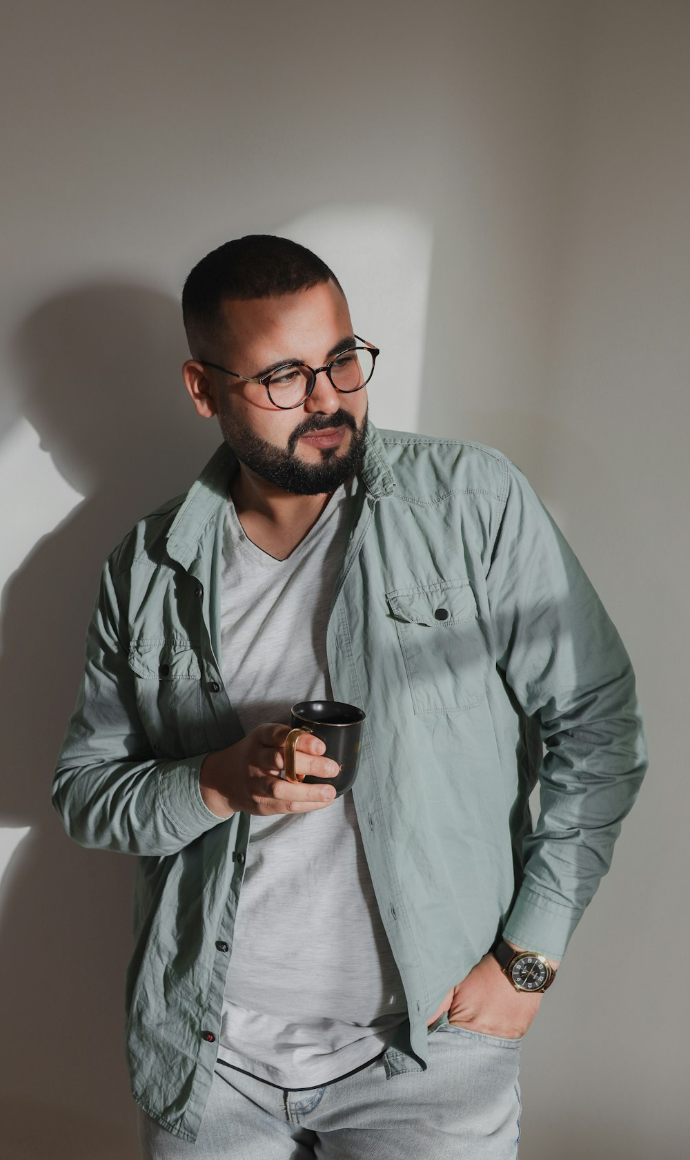 a man with a beard and glasses holding a cell phone