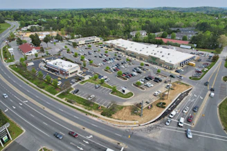 An aerial view of a bustling retail center with parking and surrounding commercial properties.