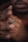 Close-up of a hand wearing a detailed coin ring with a blurred natural background.
