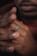 Close-up of a hand wearing a detailed coin ring with a blurred natural background.