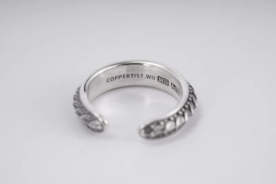 Minimalist silver ring with a precise engraving symbolizing mental strength.