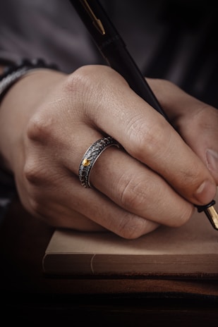 Hands gently holding a vintage fountain pen over paper.