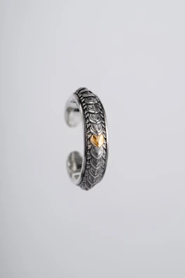 Close-up of a delicate silver ring with an intricate wave pattern inspired by the sea.
