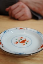 a plate with a fish design on it sitting on a table