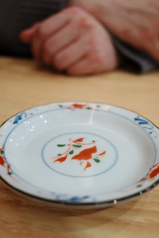a plate with a fish design on it sitting on a table