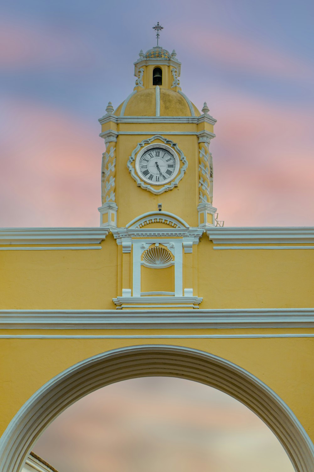 Un edificio amarillo con un reloj en la parte superior