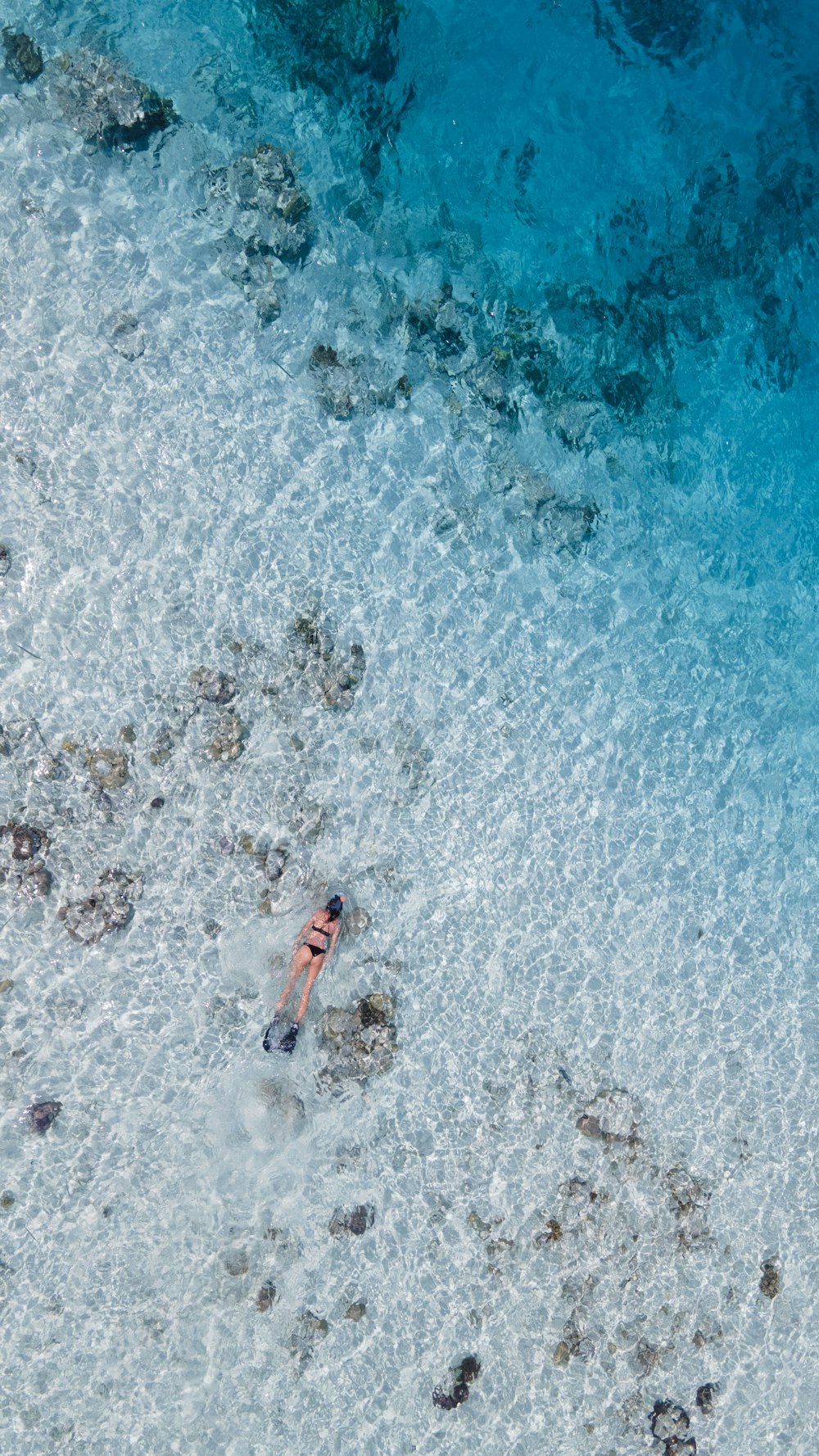 a person swimming in the ocean with a surfboard