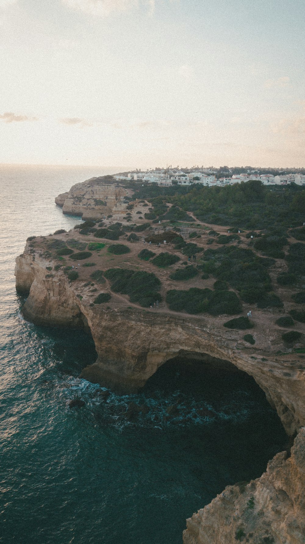 an aerial view of the ocean and a cliff